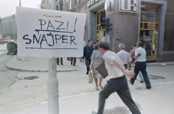 Temmuz 1992'de Saraybosna şehir merkezindeki bir kavşağı geçmek için acele eden insanlar, üzerinde 